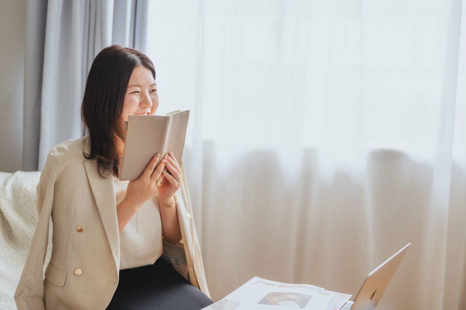 やわらかな光のそばで、ノートを手に微笑む様子